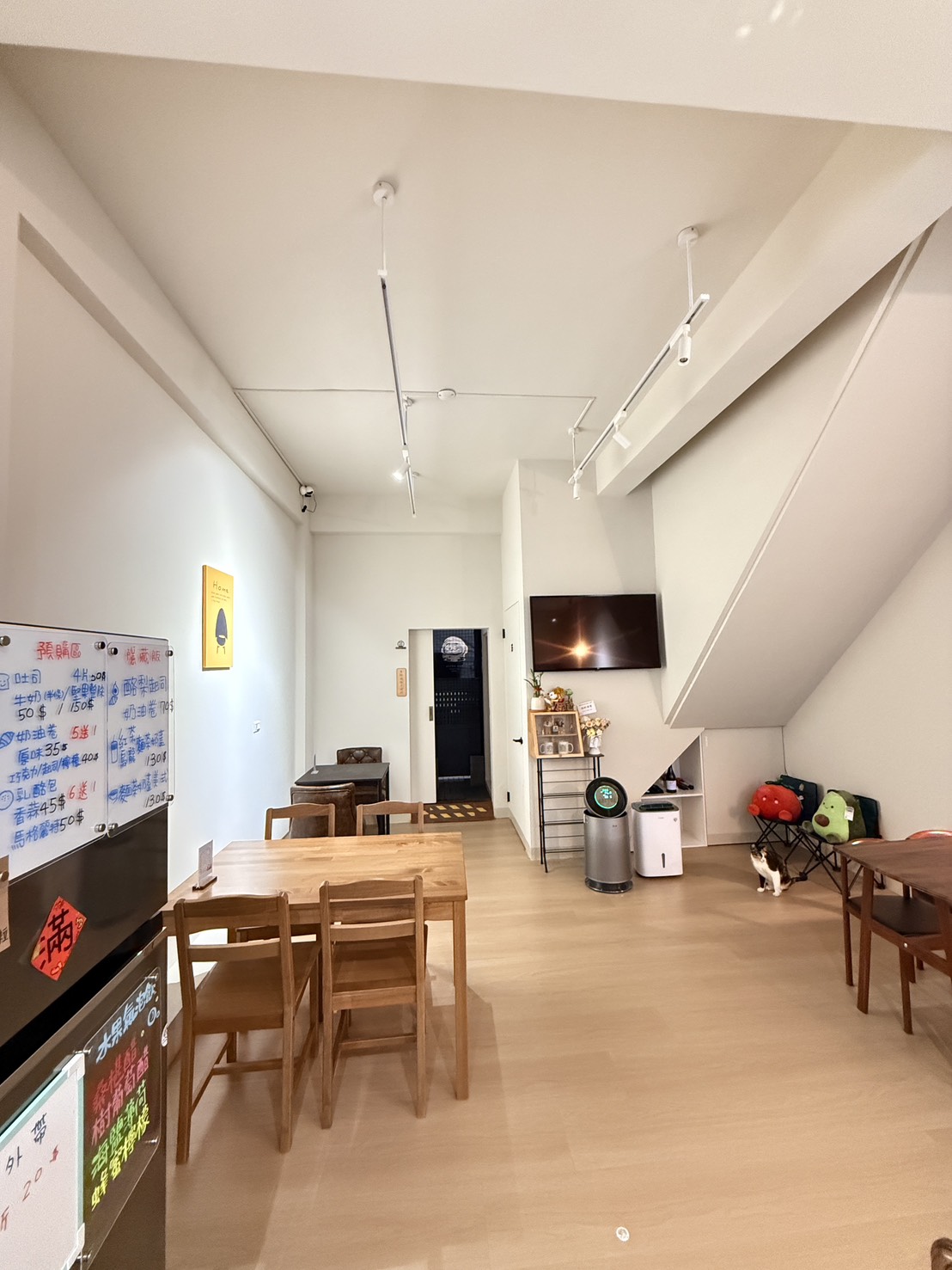 吾喵 CAFÉ 店內空間，白牆、木桌與吧檯，適合場地租借